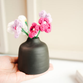 black bud vase with mini crochet daisies