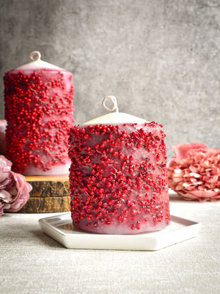 "Pillar candle with red dried flowers"
