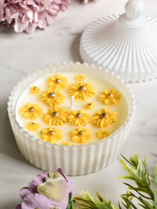 "Soy wax candle with yellow daisy flower decoration"